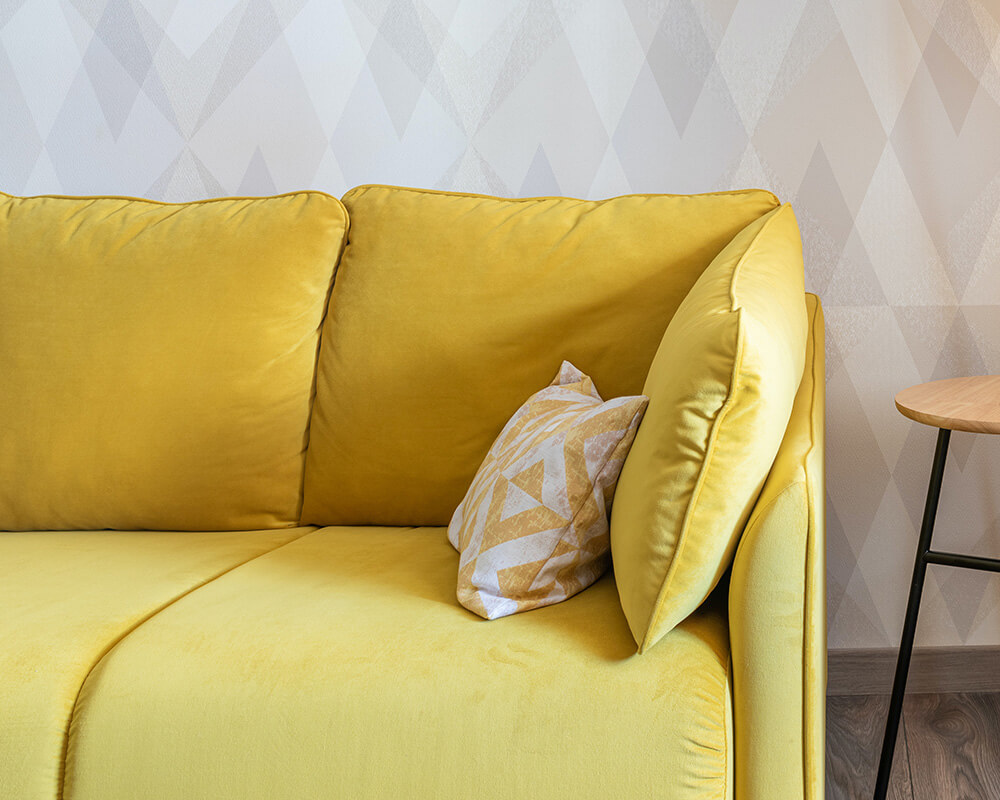 mustársárga kétszemélyes kanapé a nappaliban